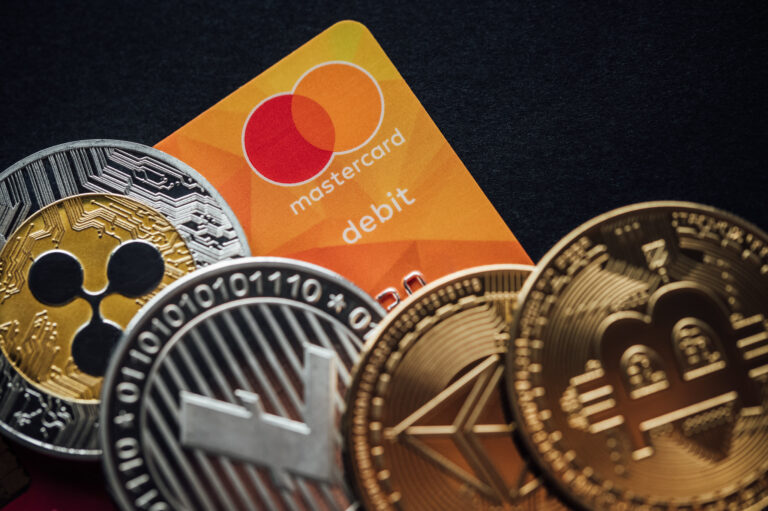 Close-up of a crypto currency physical coins on a mastercard credit card